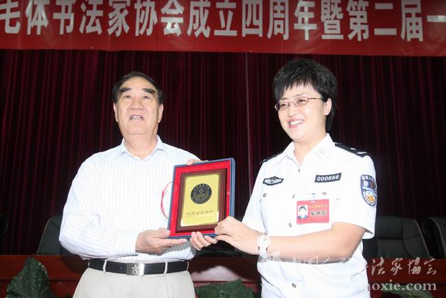 北京警察学院院长柴艳茹回赠景学勤会长院徽