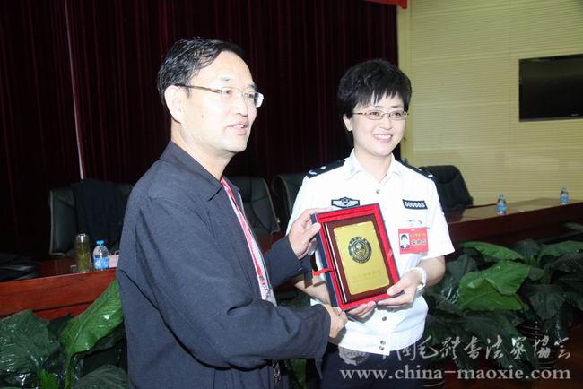 北京警察学院院长柴艳茹回赠姚二峰副会长院徽